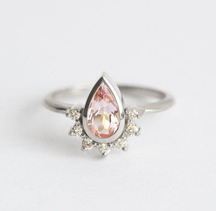 Pear-shaped pink sapphire with diamond halo