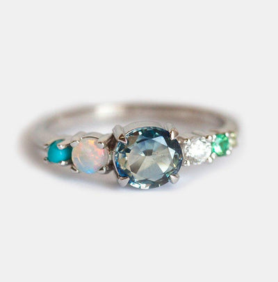 Blue round sapphire cluster ring with turqoise, emerald, opal and diamond stones