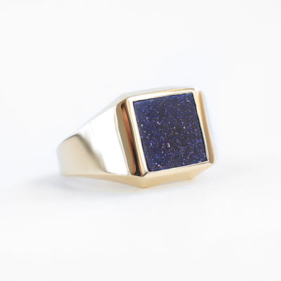 Men's goldstone signet ring with blue square gemstone in gold and platinum.