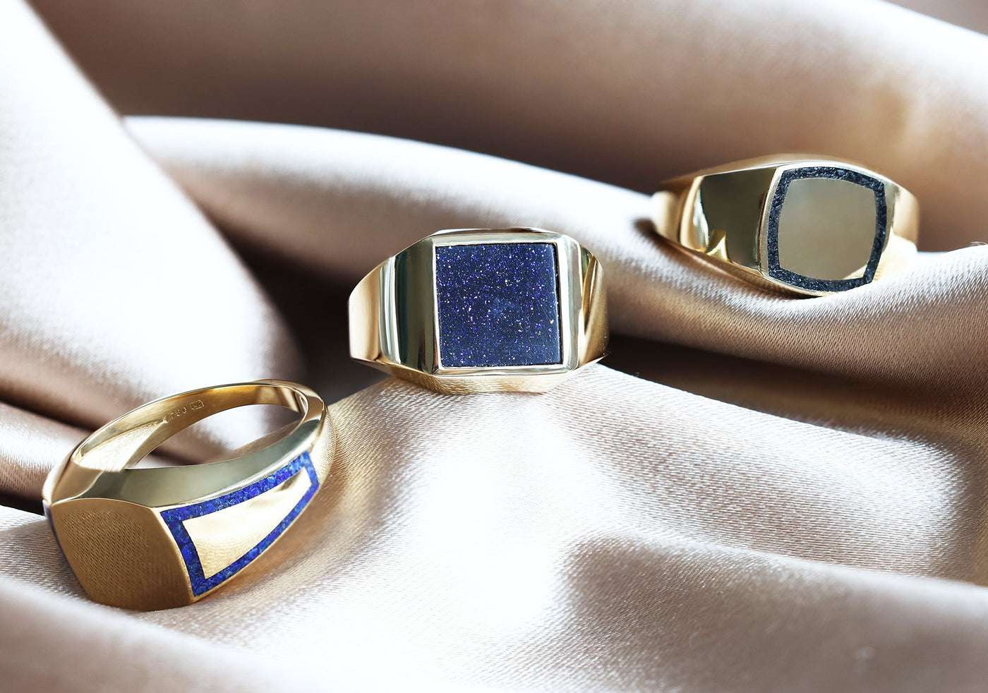 Men's goldstone signet ring in gold and platinum, showcasing a group of gold rings with blue stones.