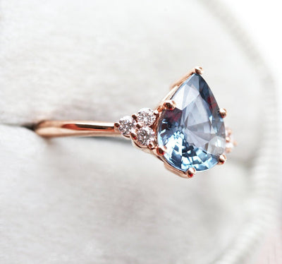 Pear-shaped peach sapphire ring with diamond cluster
