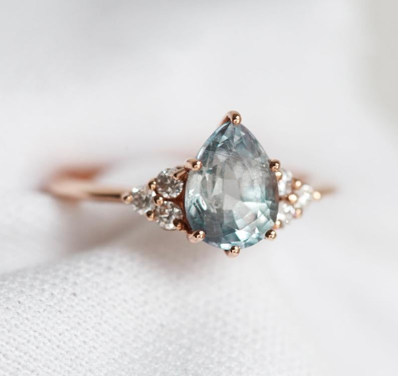 Pear-shaped blue green sapphire ring with side diamonds