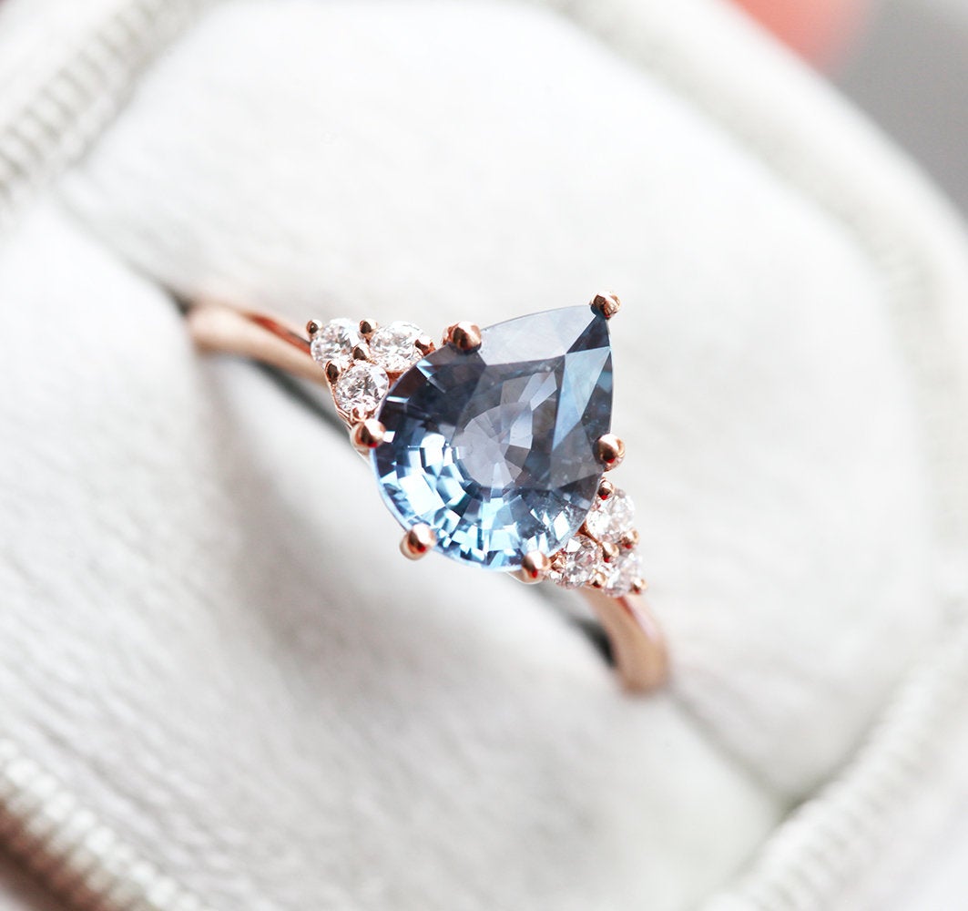 Blue pear-shaped sapphire ring with diamond cluster