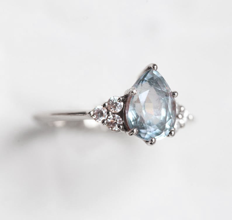 Pear-shaped sapphire ring with diamond cluster