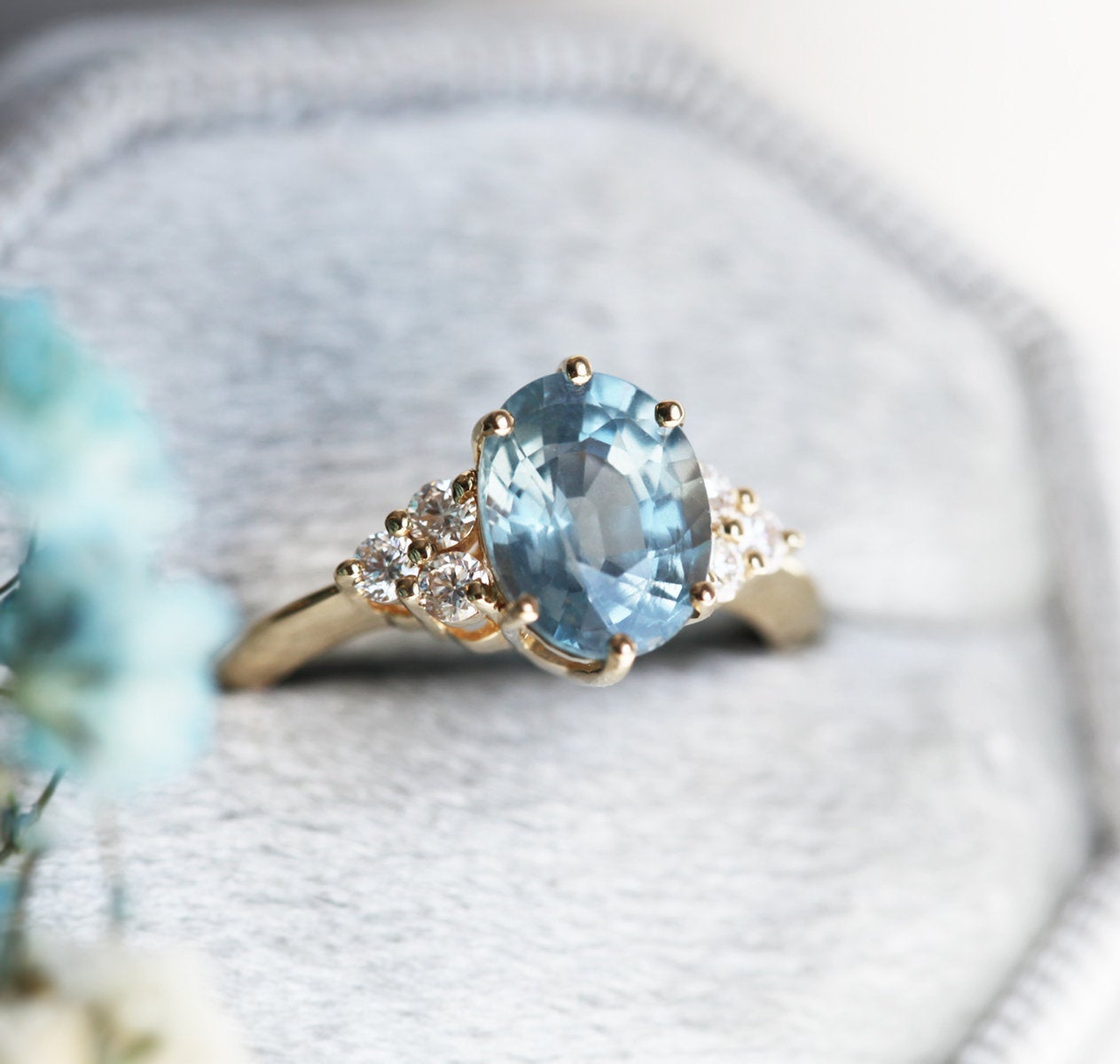 Oval-shaped blue sapphire ring with diamond cluster