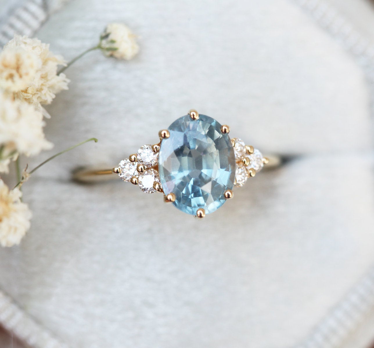 Oval-shaped blue sapphire ring with diamond cluster