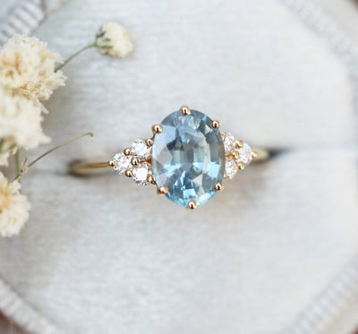Oval-shaped blue sapphire ring with diamond cluster