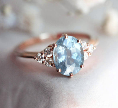 Oval-shaped blue sapphire ring with diamond cluster