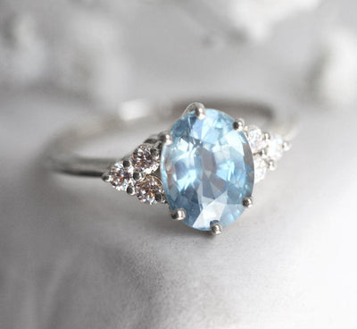 Oval-shaped blue sapphire ring with diamond cluster