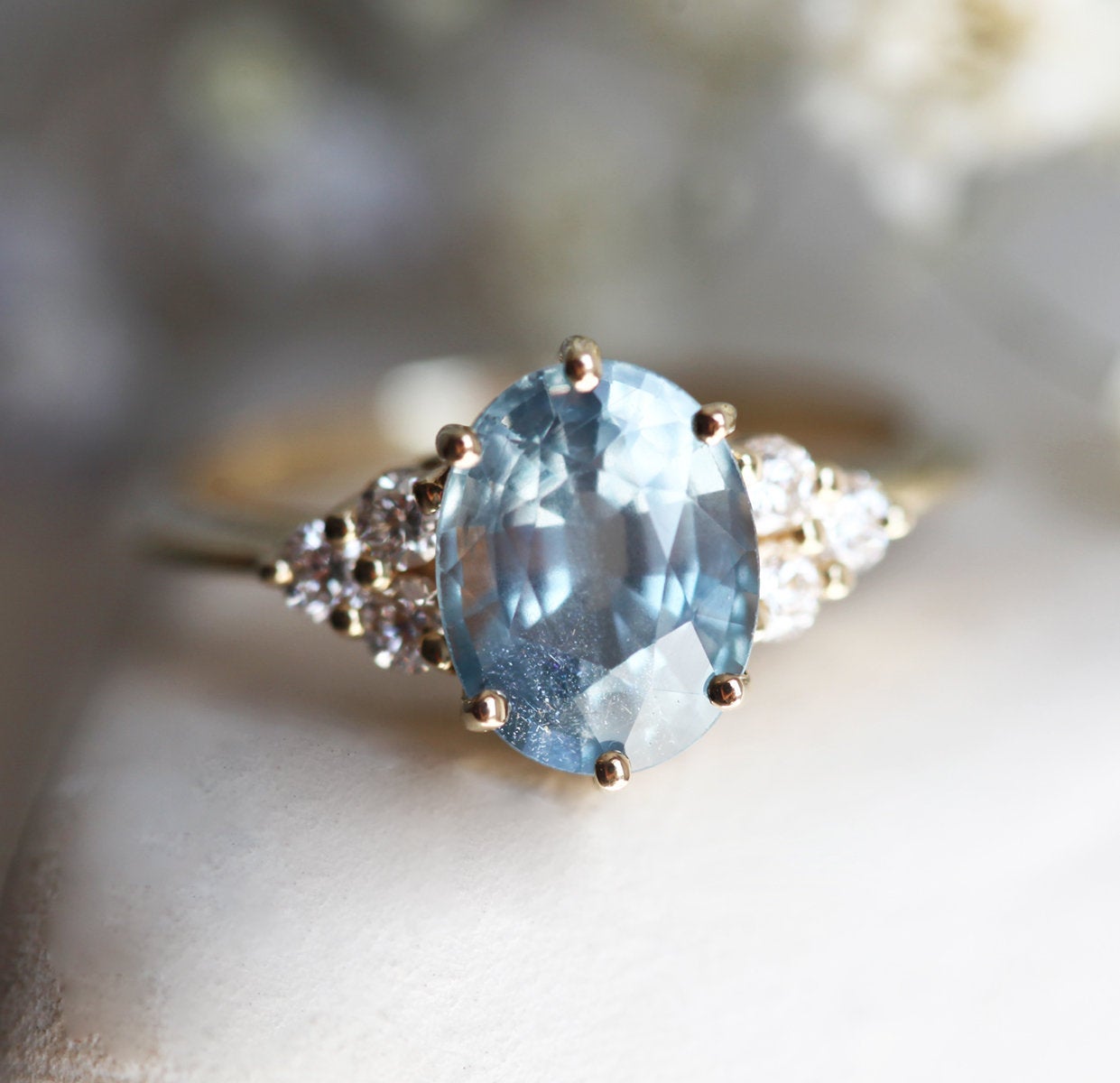 Oval-shaped blue sapphire ring with diamond cluster