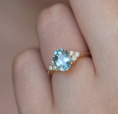 Oval-shaped blue sapphire ring with diamond cluster