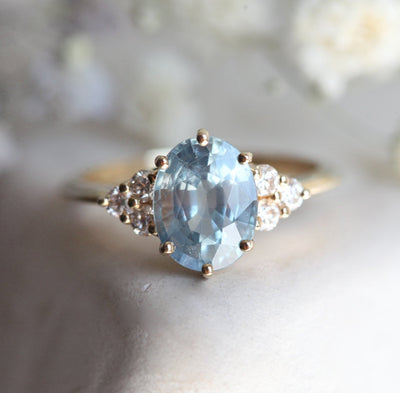 Oval-shaped blue sapphire ring with diamond cluster