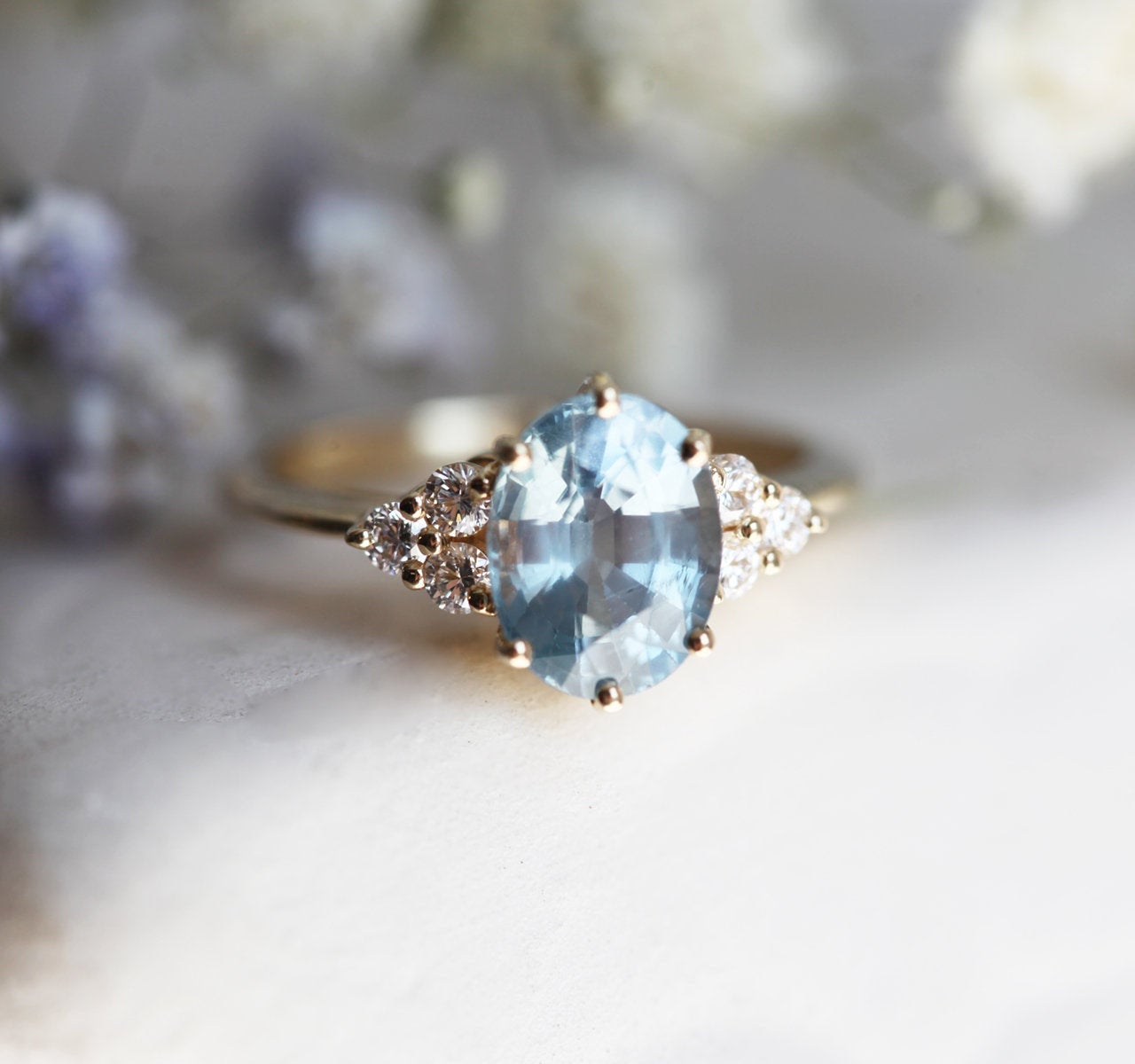 Oval-shaped blue sapphire ring with diamond cluster