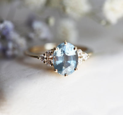 Oval-shaped blue sapphire ring with diamond cluster