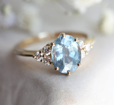 Oval-shaped blue sapphire ring with diamond cluster