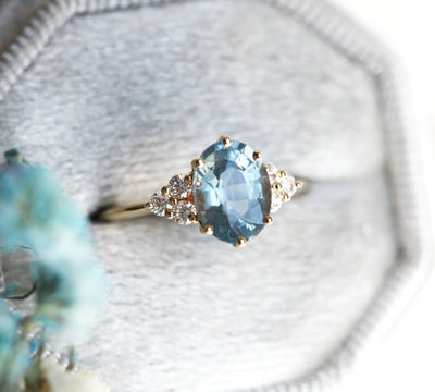 Oval-shaped blue sapphire ring with diamond cluster