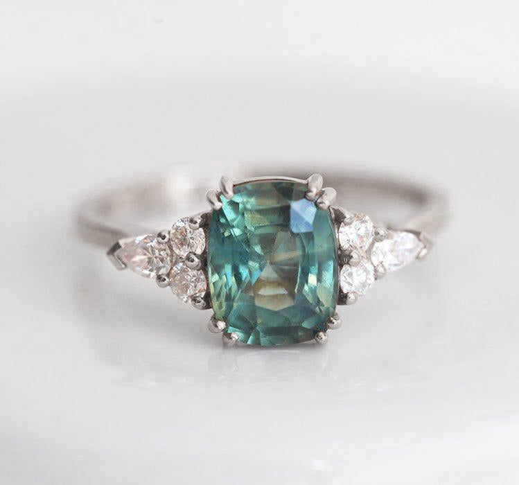 Teal cushion-cut sapphire ring with side diamonds