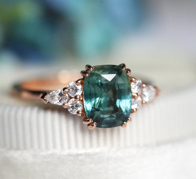 Teal cushion-cut sapphire ring with side diamonds