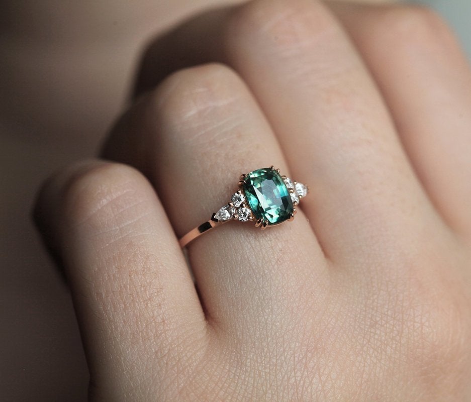 Teal cushion-cut sapphire ring with side diamonds