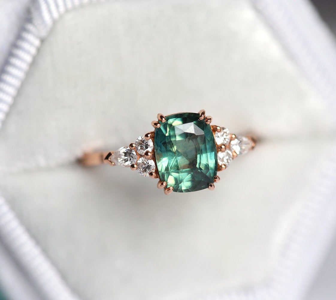 Teal cushion-cut sapphire ring with side diamonds