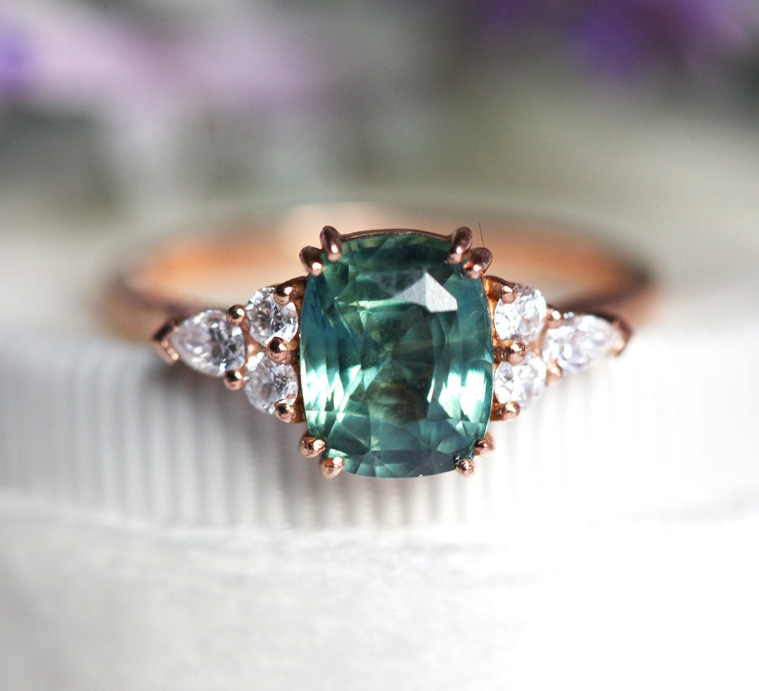 Teal cushion-cut sapphire ring with side diamonds