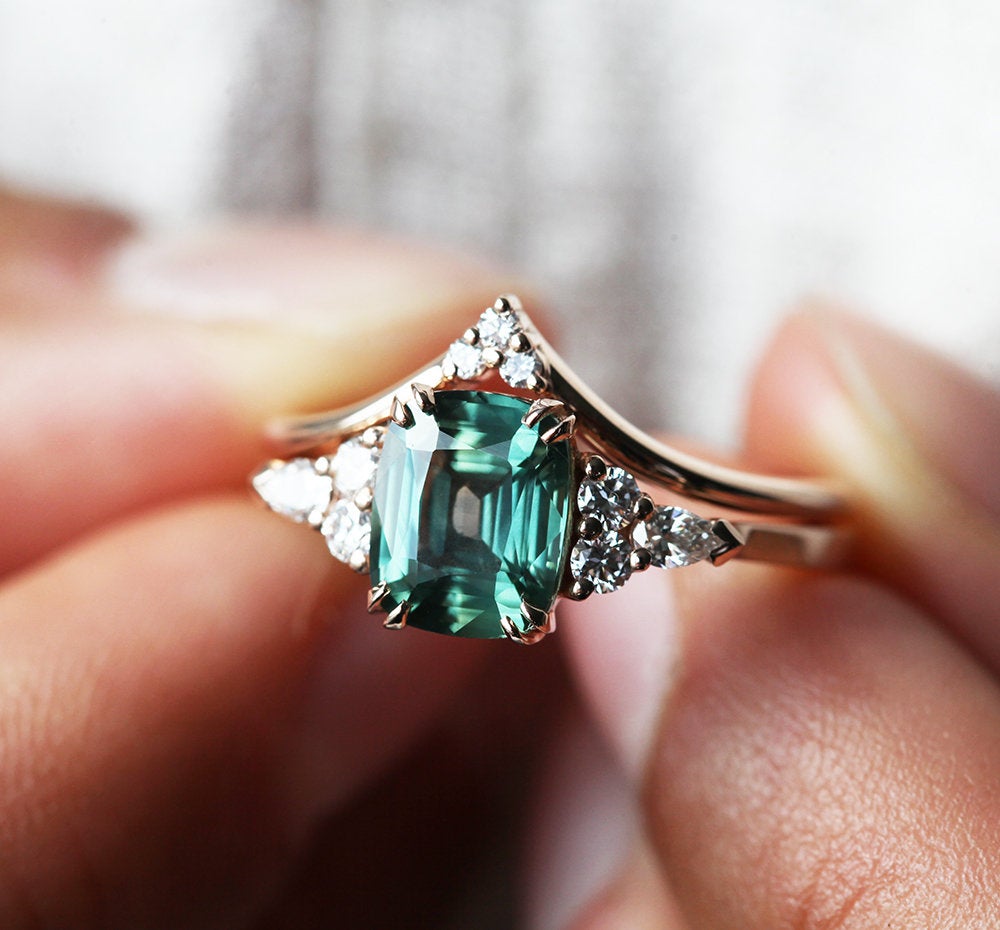 Teal cushion-cut sapphire ring with side diamonds