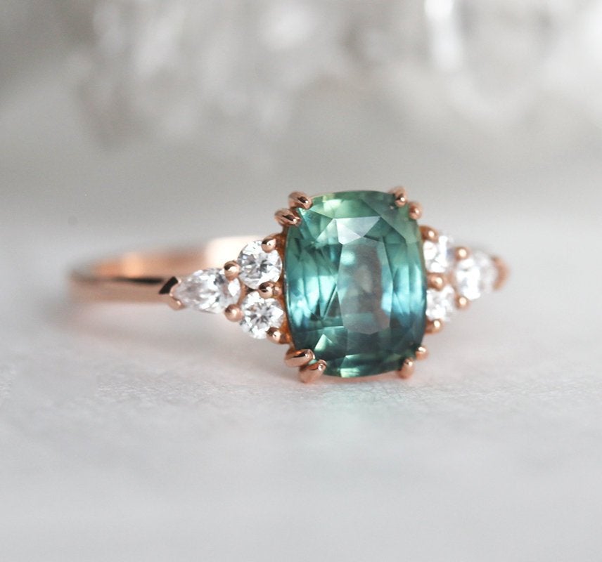 Teal cushion-cut sapphire ring with side diamonds