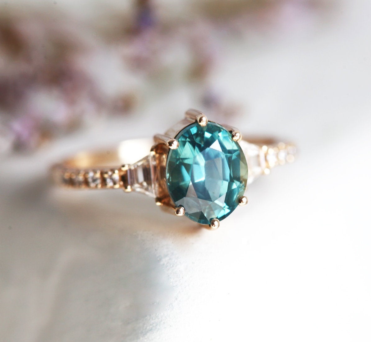 Oval teal sapphire ring with side diamonds
