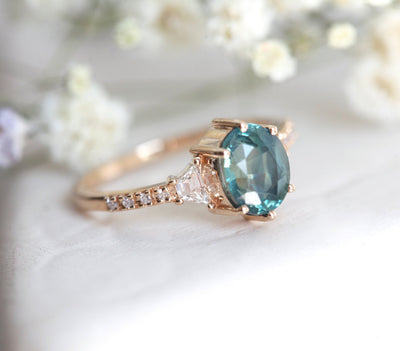 Oval teal sapphire ring with side diamonds