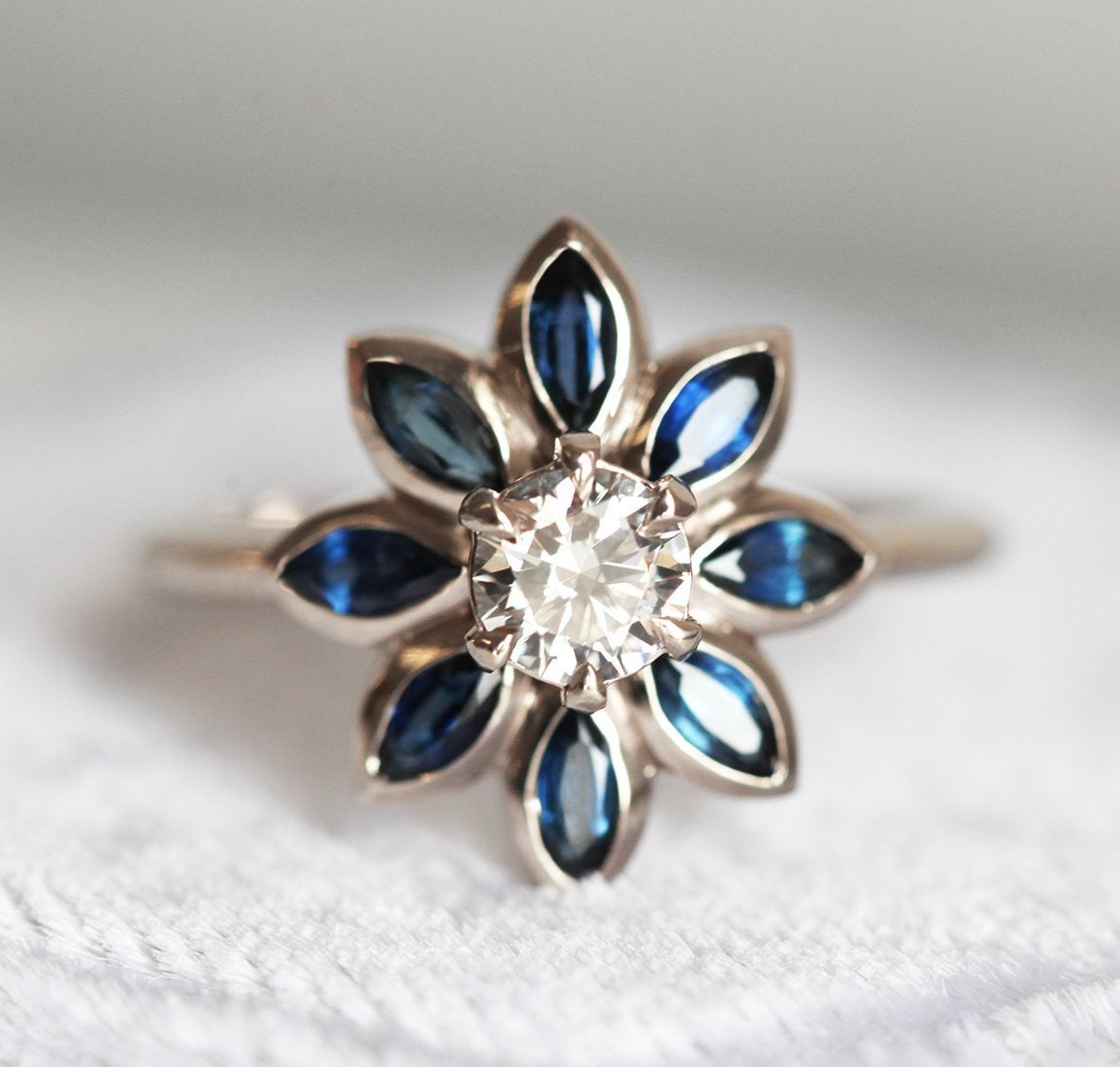 Round diamond floral ring with side sapphires