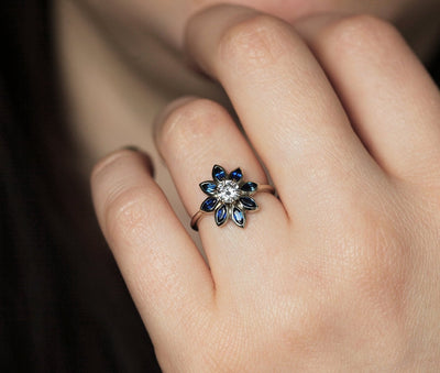 Round diamond floral ring with side sapphires