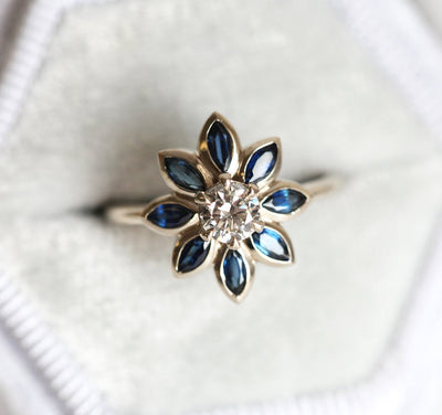 Round diamond floral ring with side sapphires