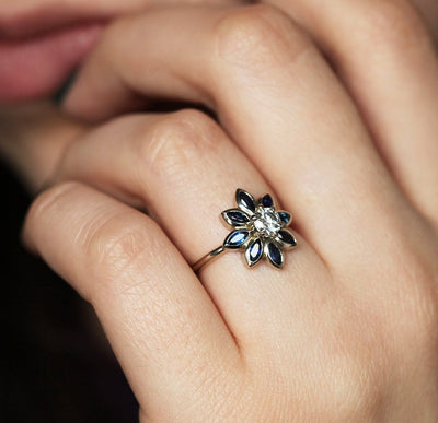 Round diamond floral ring with side sapphires