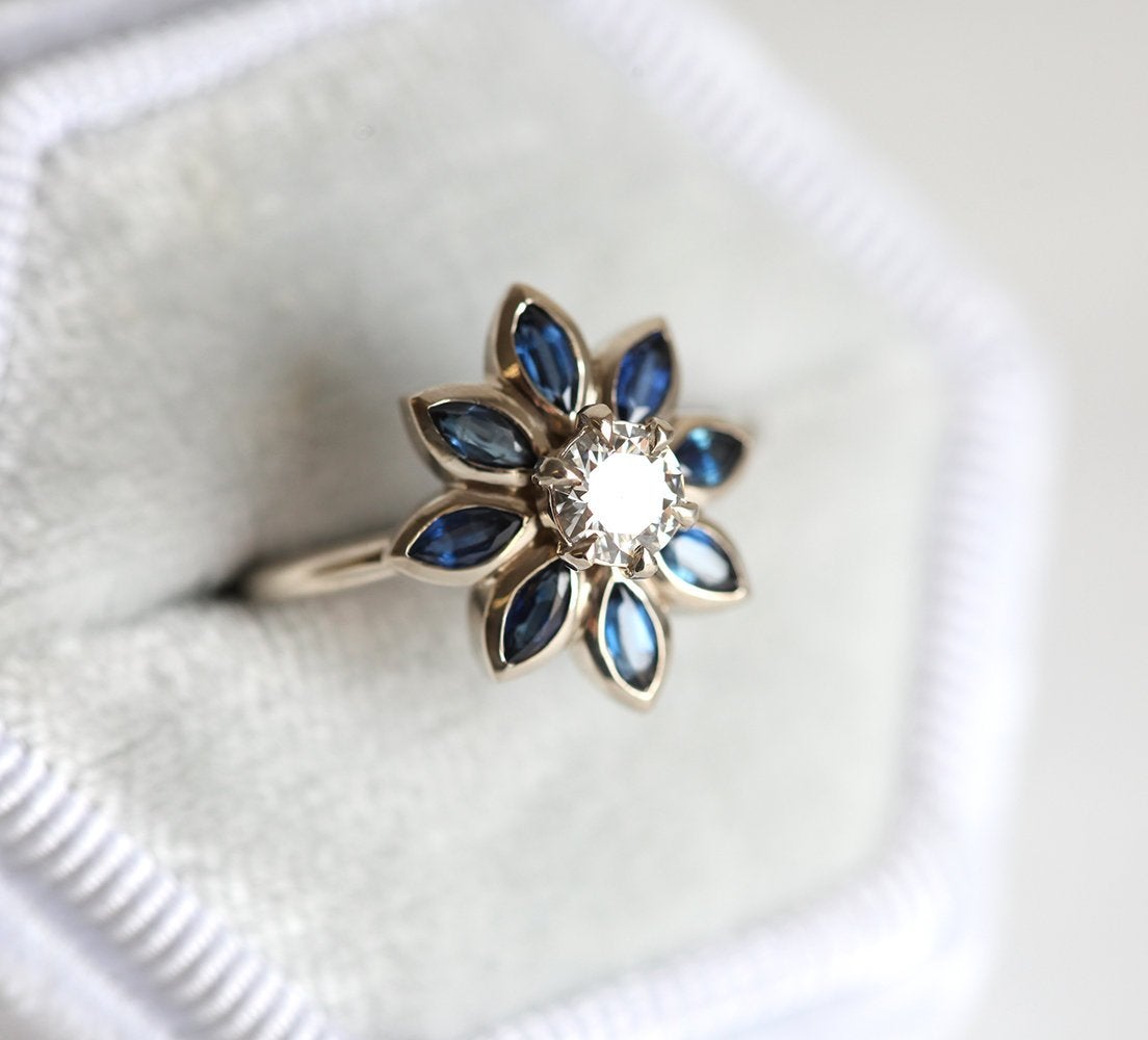 Round diamond floral ring with side sapphires