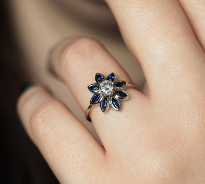 Round diamond floral ring with side sapphires