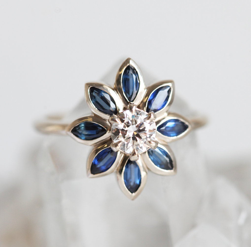 Round diamond floral ring with side sapphires