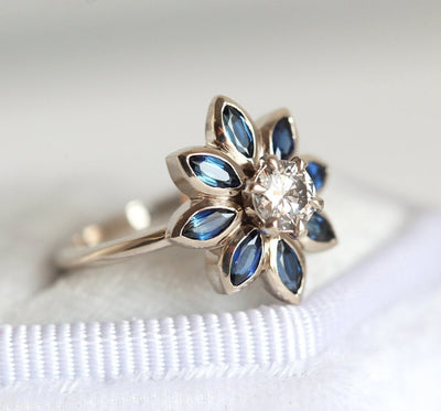 Round diamond floral ring with side sapphires