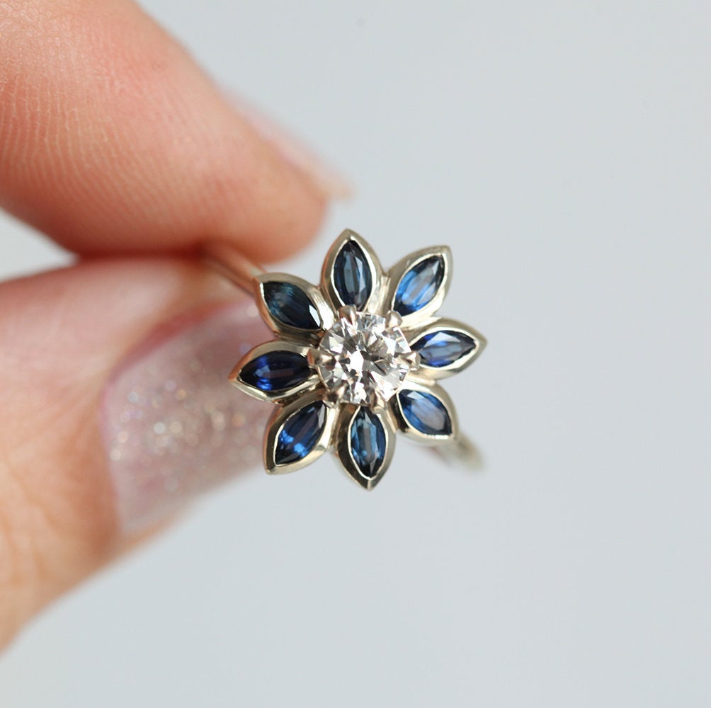 Round diamond floral ring with side sapphires