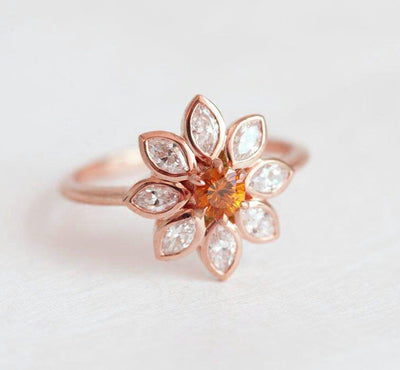 Round orange sapphire ring with side diamonds