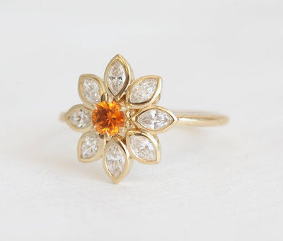 Round orange sapphire ring with side diamonds
