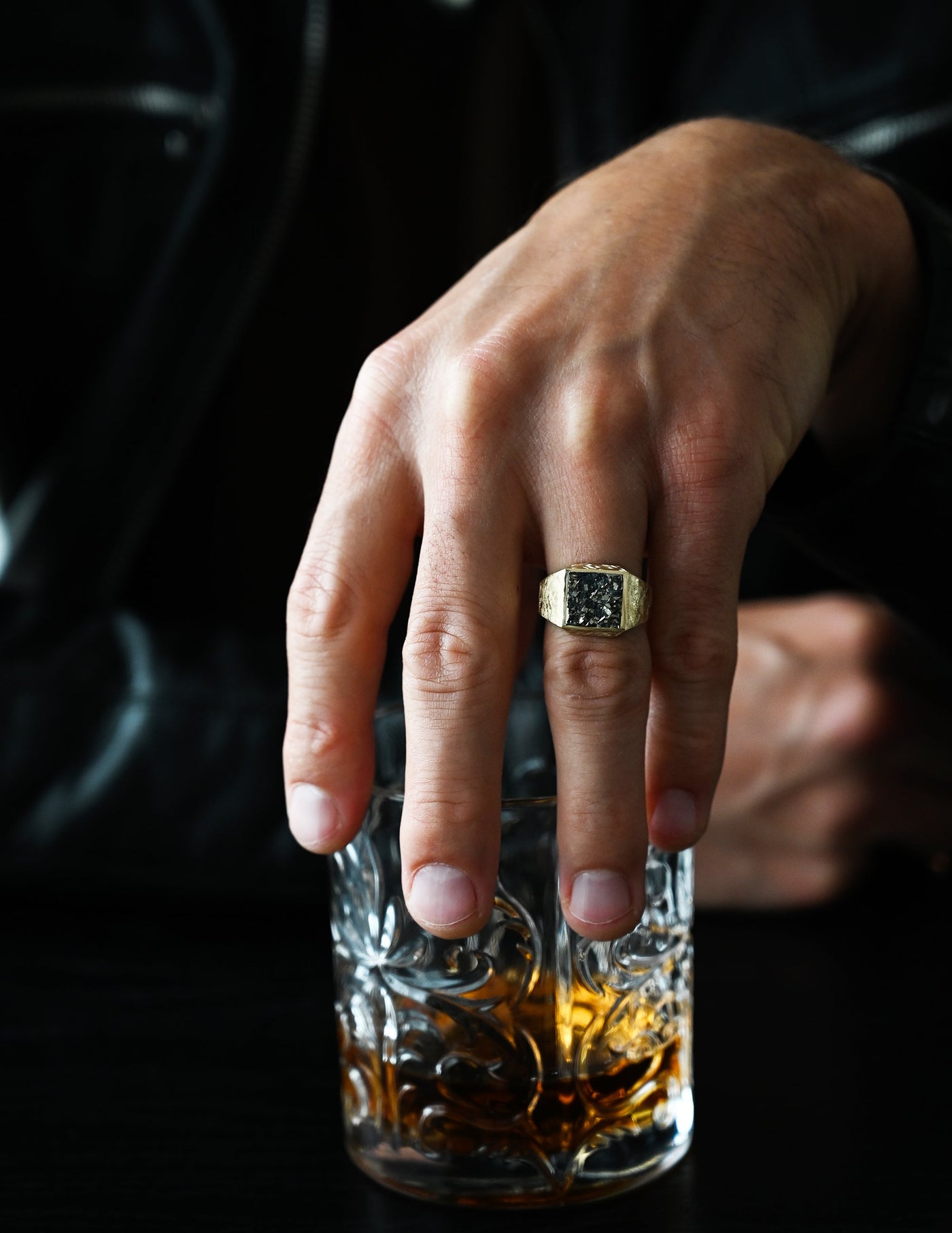 A close-up of a hand wearing the Pyrite Signet Ring, showcasing a pyrite crystal on a polished band.