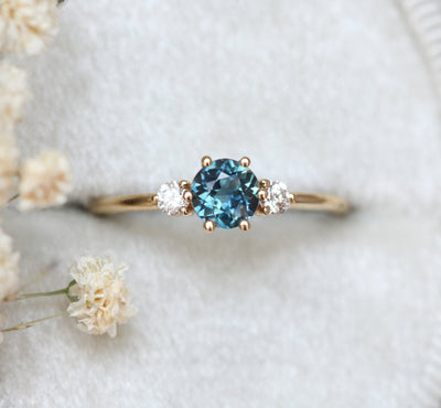 Round teal blue sapphire ring with side diamonds