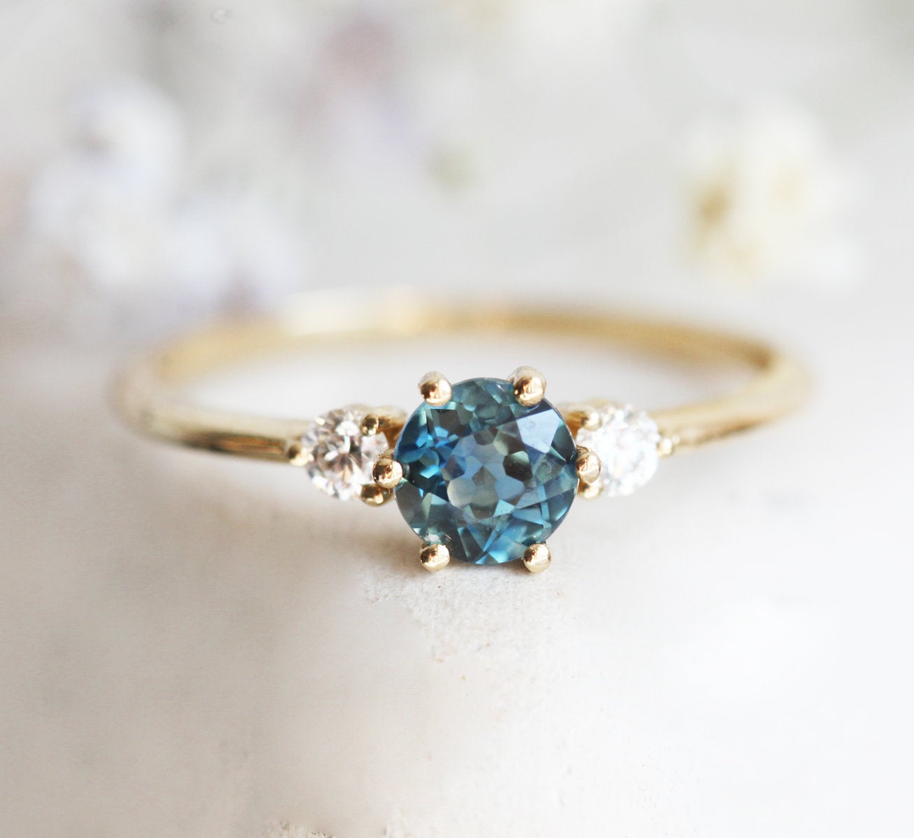 Round teal blue sapphire ring with side diamonds