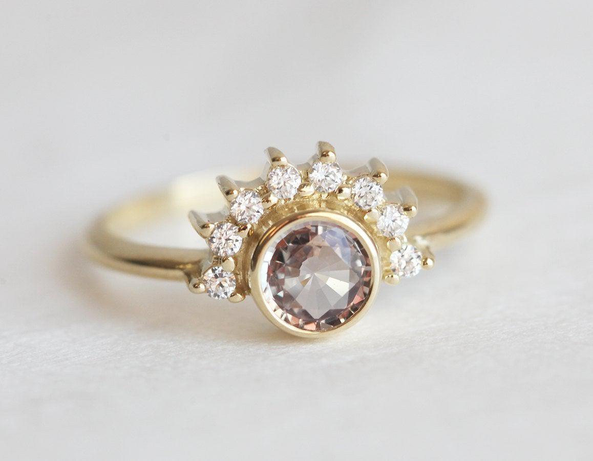 Round peach pink sapphire ring with diamond halo