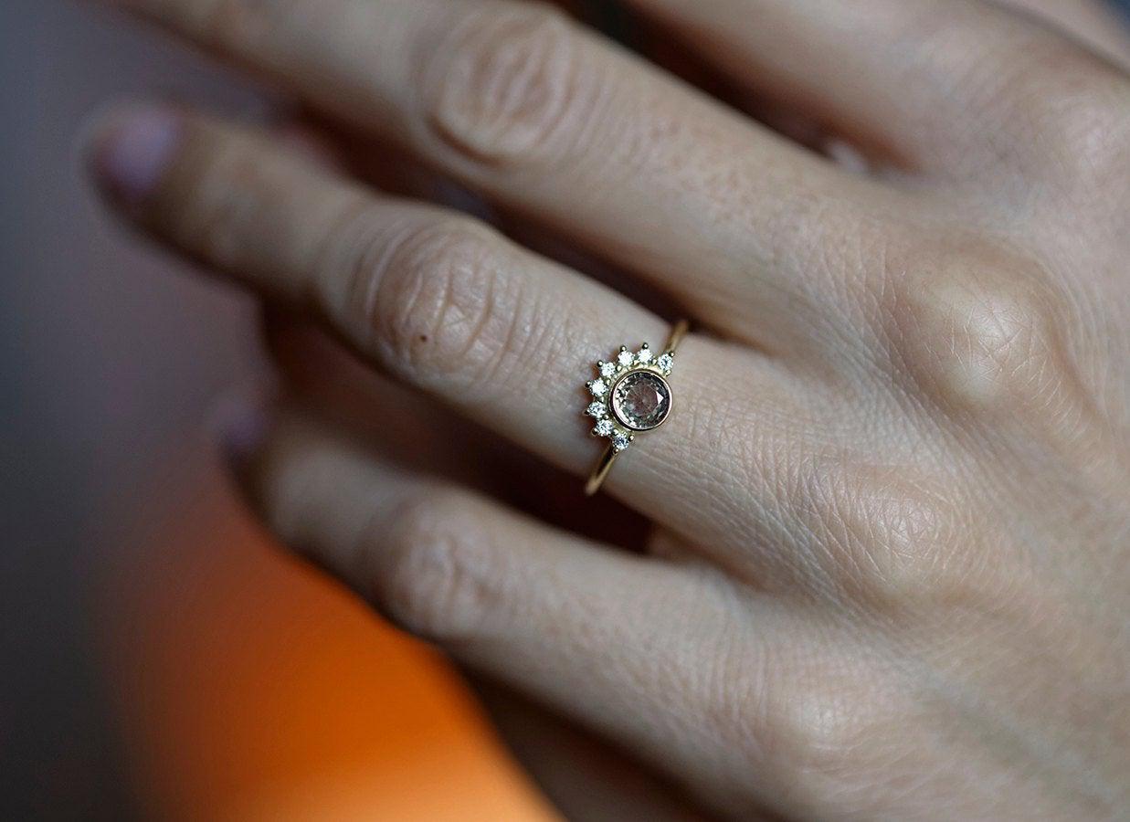 Round peach pink sapphire ring with diamond halo