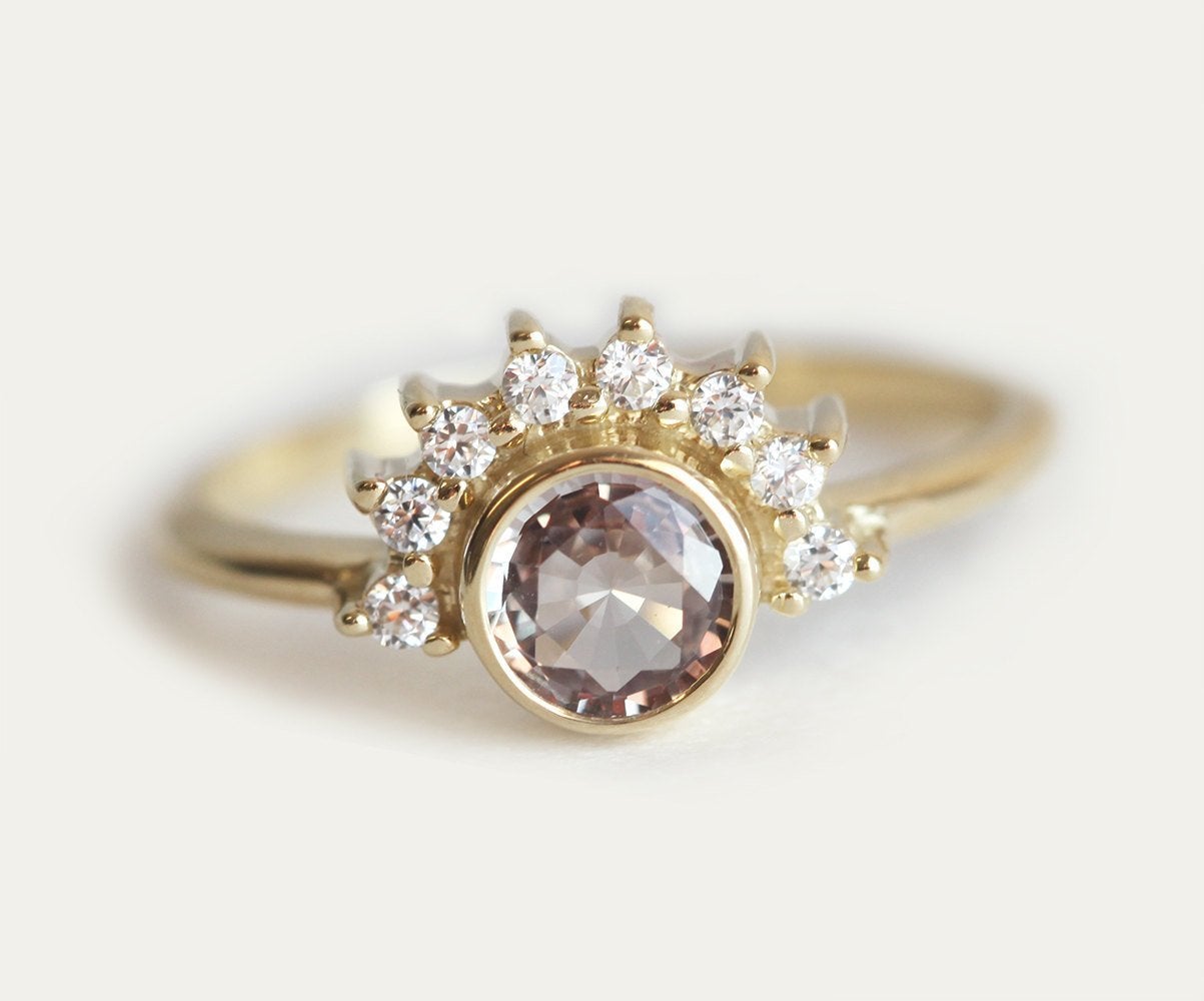 Round peach pink sapphire ring with diamond halo