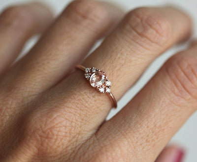 Oval-shaped peach sapphire ring with white diamond cluster
