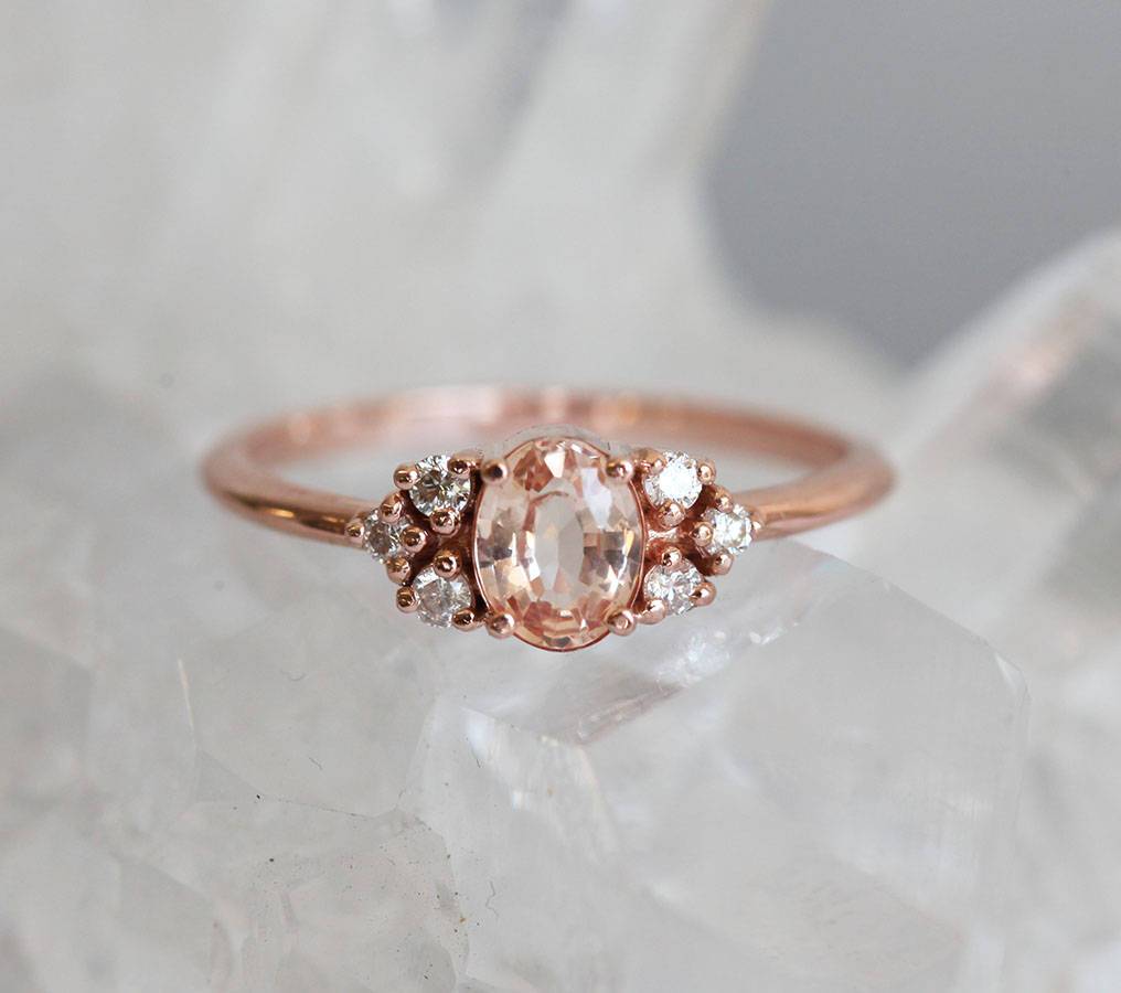 Oval-shaped peach sapphire ring with white diamond cluster