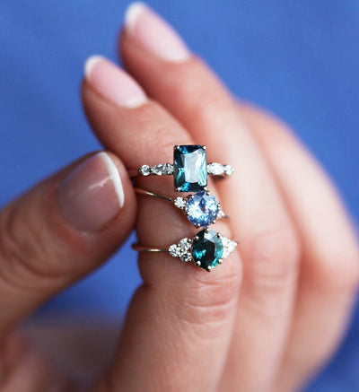 Radiant teal sapphire ring with white side diamonds