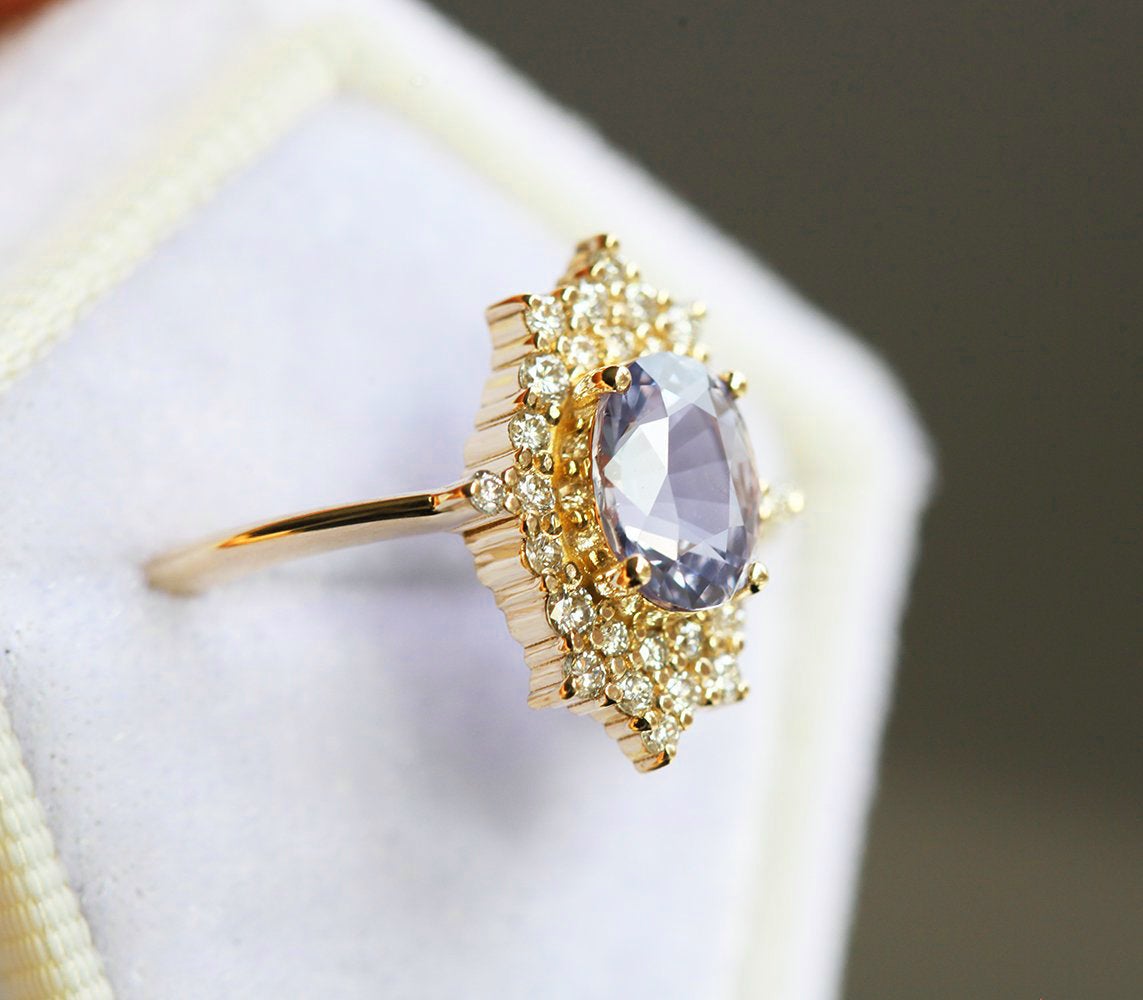 Oval-shaped lavender sapphire ring with diamond halo